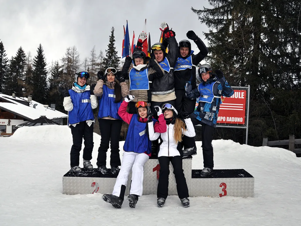 Gruppe jubelt auf dem Siegertreppchen.